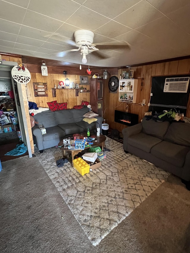 carpeted living room featuring ceiling fan, wood walls, and a wall mounted AC