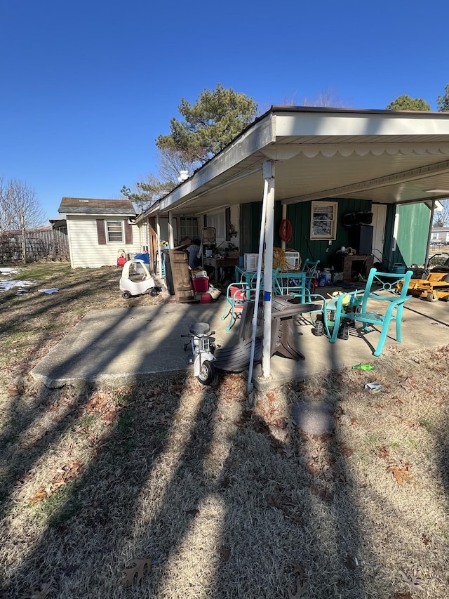 view of side of property with a storage shed and a patio