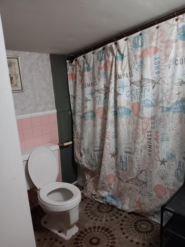 bathroom with tile walls and toilet