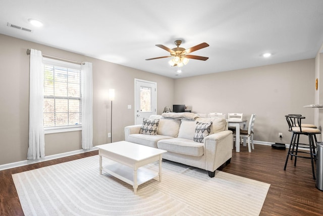 living room with ceiling fan and dark hardwood / wood-style flooring