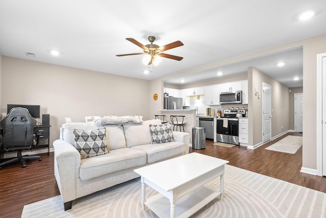 living room with ceiling fan and dark wood-type flooring