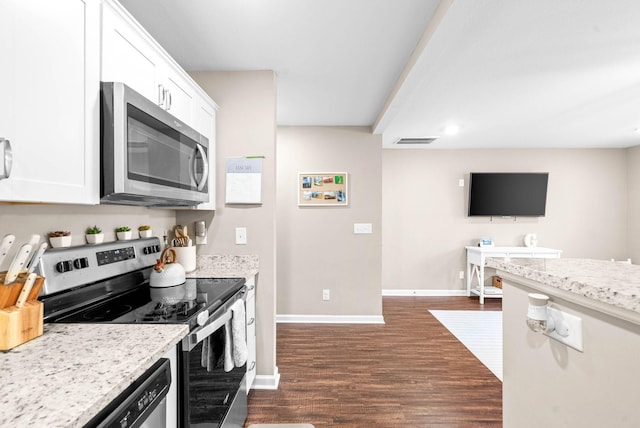 kitchen featuring dark hardwood / wood-style floors, appliances with stainless steel finishes, white cabinets, and light stone countertops