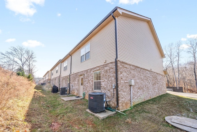 view of property exterior featuring a lawn and central AC