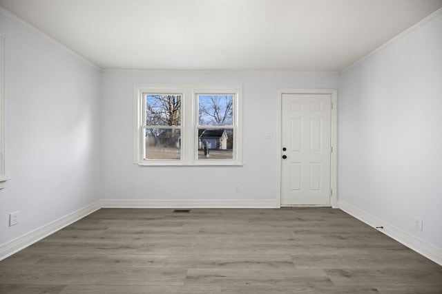 empty room featuring ornamental molding and hardwood / wood-style flooring