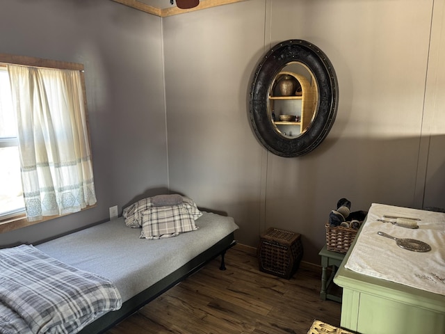 bedroom with multiple windows and dark hardwood / wood-style flooring