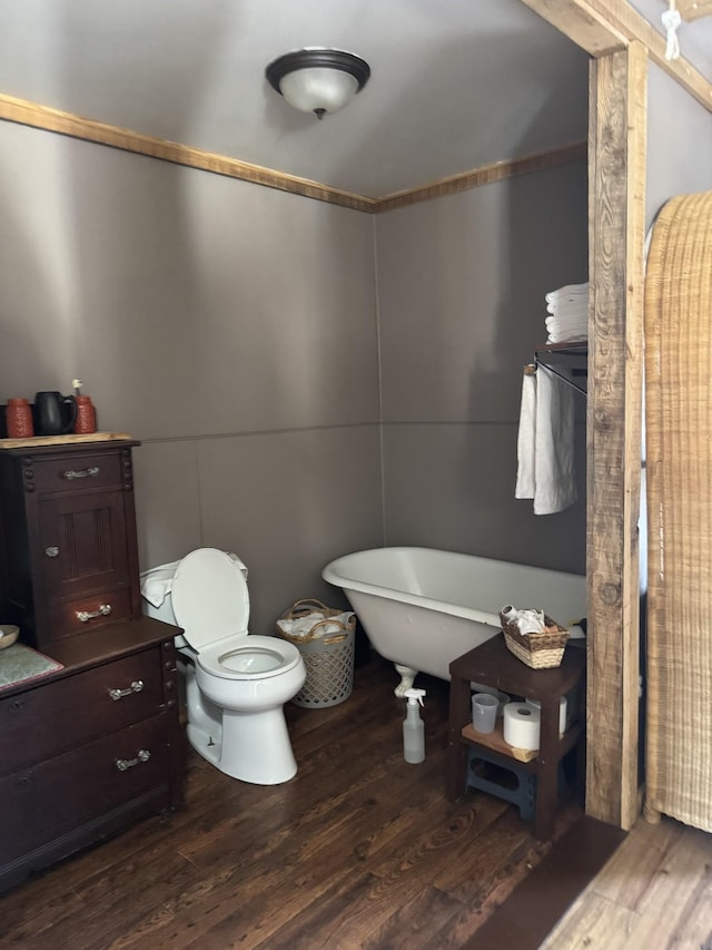 bathroom featuring hardwood / wood-style flooring, a bathing tub, and toilet