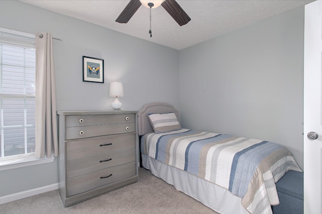 carpeted bedroom with ceiling fan and a textured ceiling