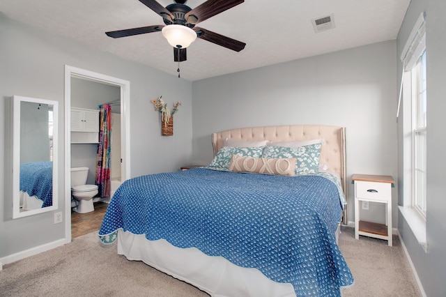 bedroom with ceiling fan, a spacious closet, ensuite bath, and carpet floors