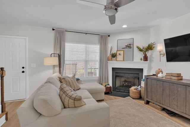 living room with light hardwood / wood-style floors and ceiling fan