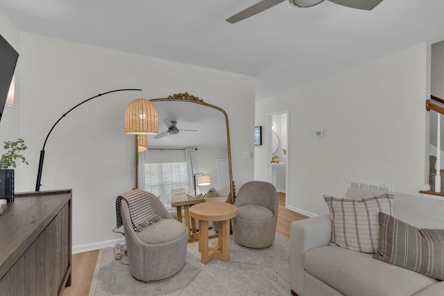 living room featuring ceiling fan and light hardwood / wood-style floors