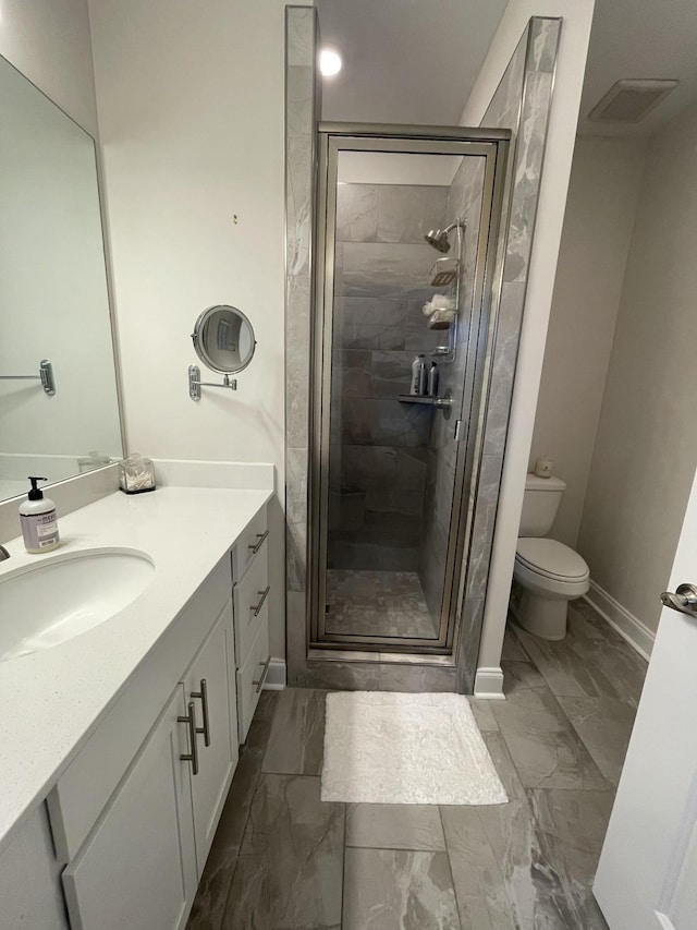 bathroom featuring toilet, vanity, and a shower with door