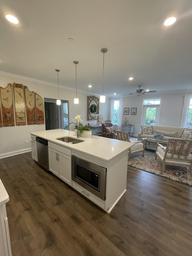 kitchen with white cabinetry, an island with sink, appliances with stainless steel finishes, hanging light fixtures, and sink