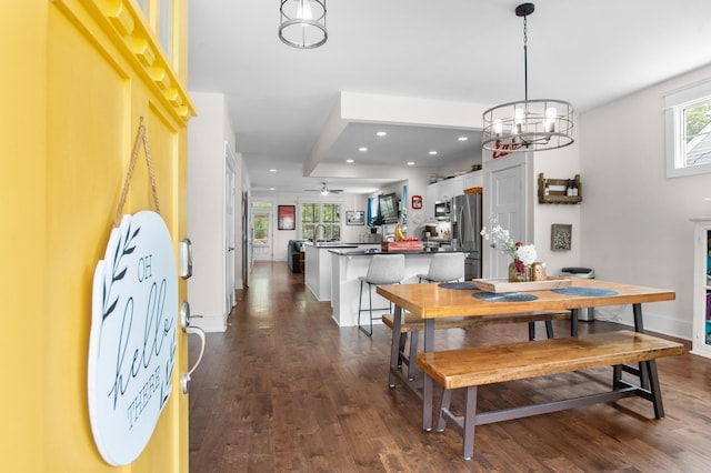 dining area with dark wood-type flooring and a notable chandelier