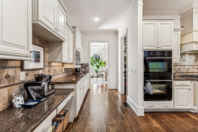 kitchen featuring white cabinetry, double oven, and dark stone countertops