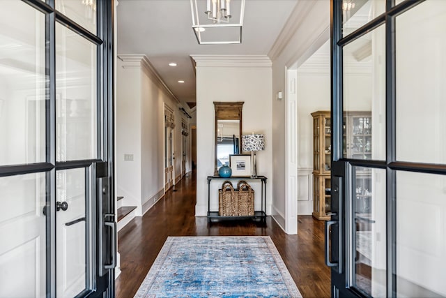 foyer with dark wood-type flooring and ornamental molding