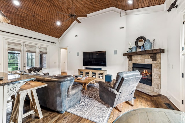 living room featuring wood-type flooring, crown molding, french doors, and a fireplace