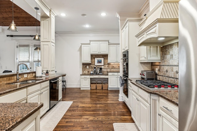 kitchen featuring black appliances, dark stone countertops, decorative backsplash, sink, and hanging light fixtures