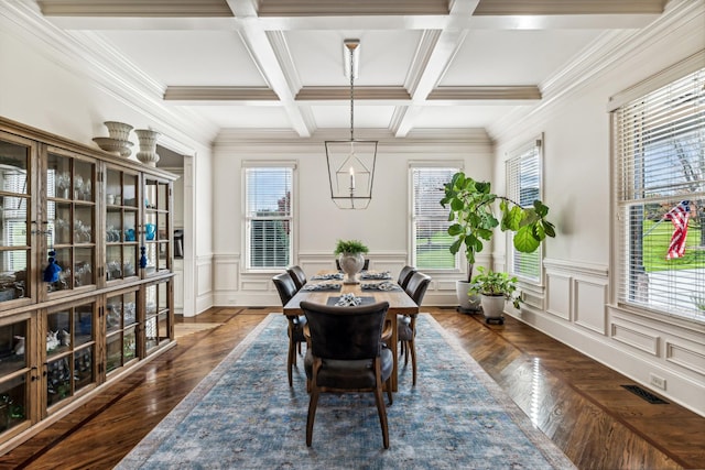 dining area featuring dark wood-type flooring, beamed ceiling, crown molding, and coffered ceiling