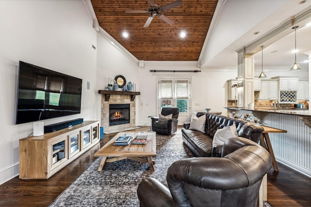 living room featuring ceiling fan, vaulted ceiling, wood ceiling, a stone fireplace, and dark hardwood / wood-style flooring