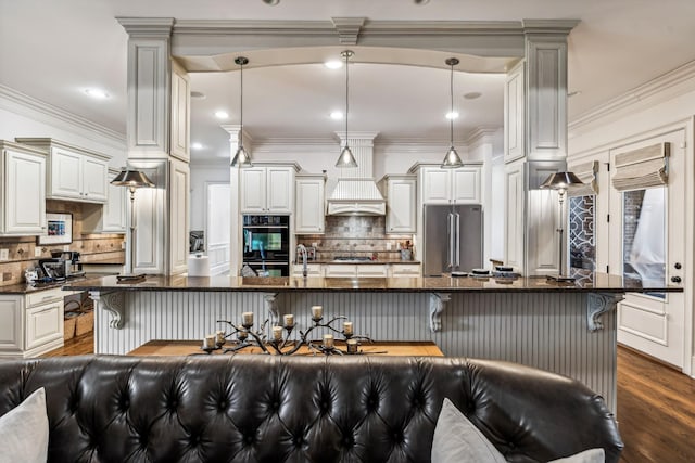 kitchen featuring a breakfast bar area, stainless steel appliances, decorative backsplash, dark hardwood / wood-style floors, and hanging light fixtures