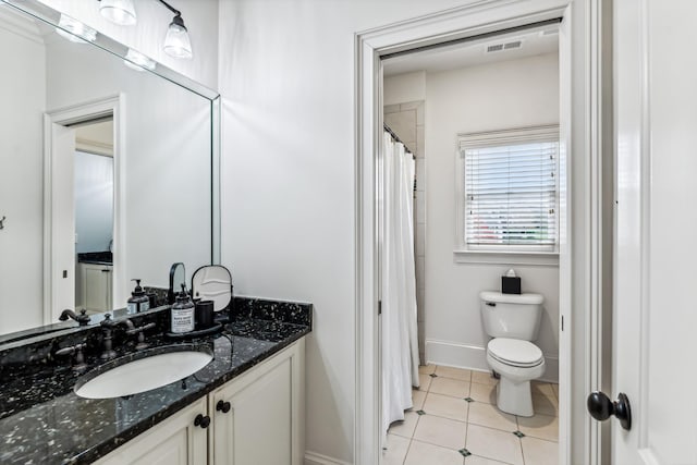 bathroom featuring toilet, vanity, walk in shower, and tile patterned flooring