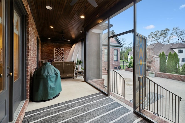 sunroom featuring ceiling fan and wooden ceiling