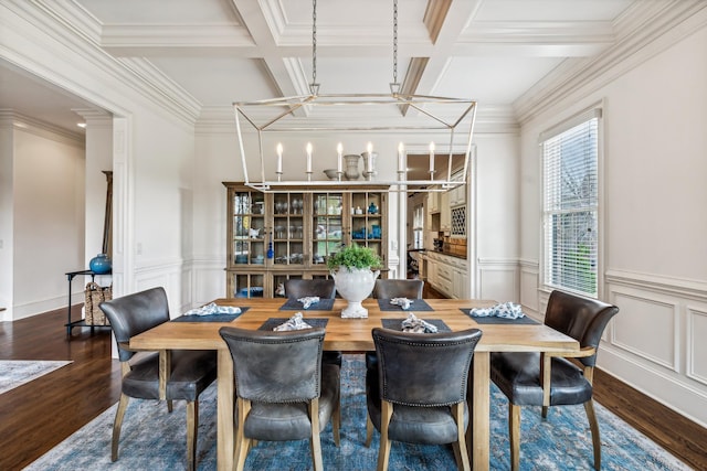 dining area with beam ceiling, wood-type flooring, a notable chandelier, crown molding, and coffered ceiling