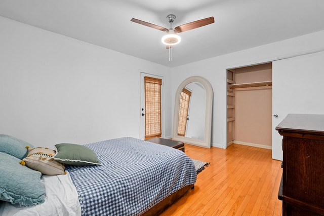 bedroom with light wood-type flooring, ceiling fan, and a closet