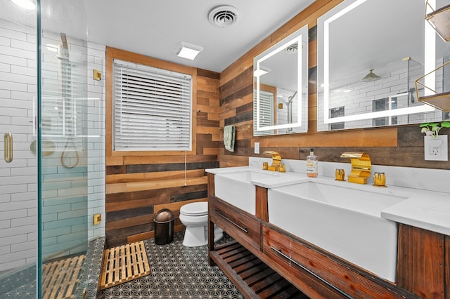 bathroom featuring toilet, vanity, wood walls, and a shower with shower door