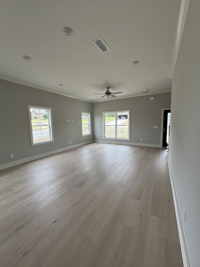 empty room featuring ceiling fan, crown molding, and light hardwood / wood-style floors