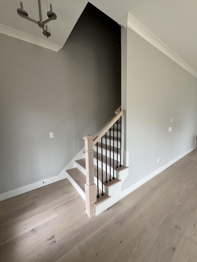 stairway featuring hardwood / wood-style flooring and crown molding