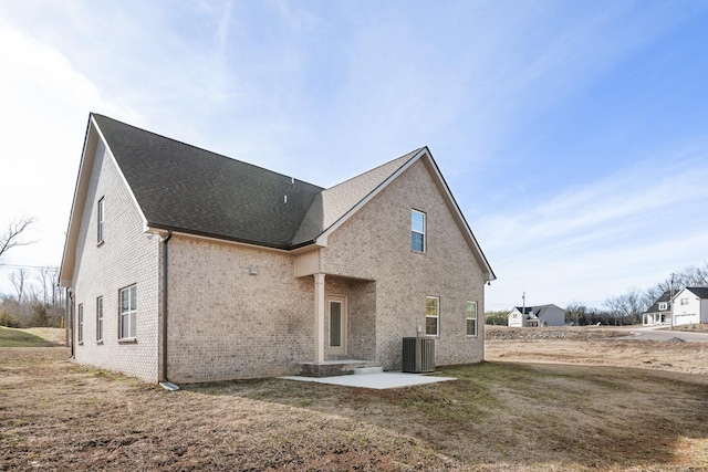 back of property with cooling unit, a yard, and a patio area