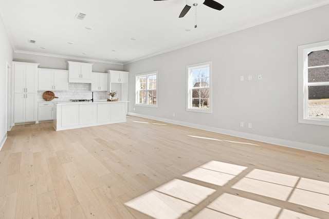 unfurnished living room featuring ornamental molding, ceiling fan, and light wood-type flooring