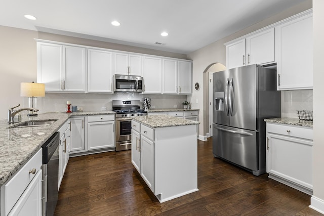 kitchen featuring sink, light stone countertops, white cabinets, and appliances with stainless steel finishes