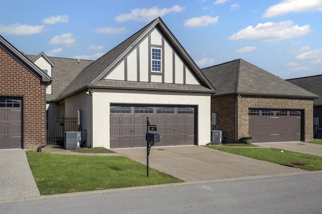 view of front facade featuring cooling unit, a garage, and a front yard