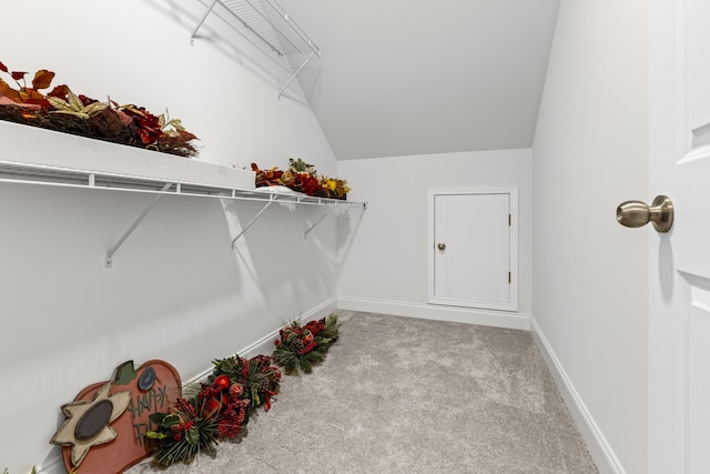 walk in closet featuring light carpet and lofted ceiling