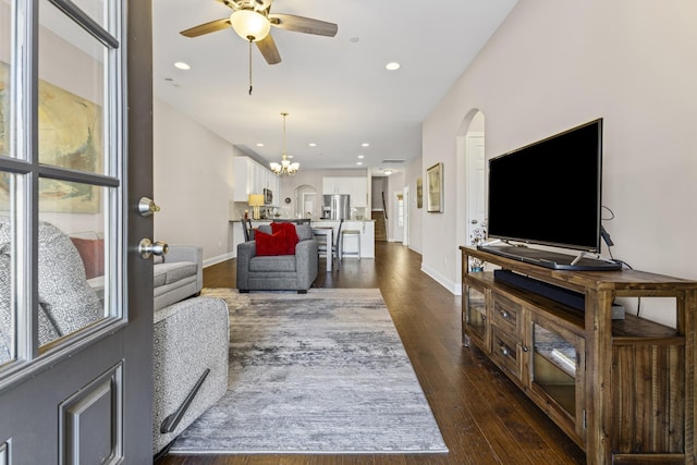 living room featuring dark hardwood / wood-style floors and ceiling fan with notable chandelier