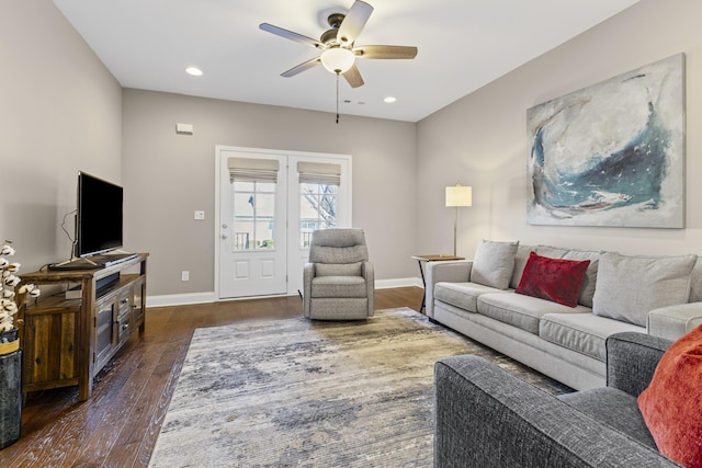 living room featuring ceiling fan and dark hardwood / wood-style floors