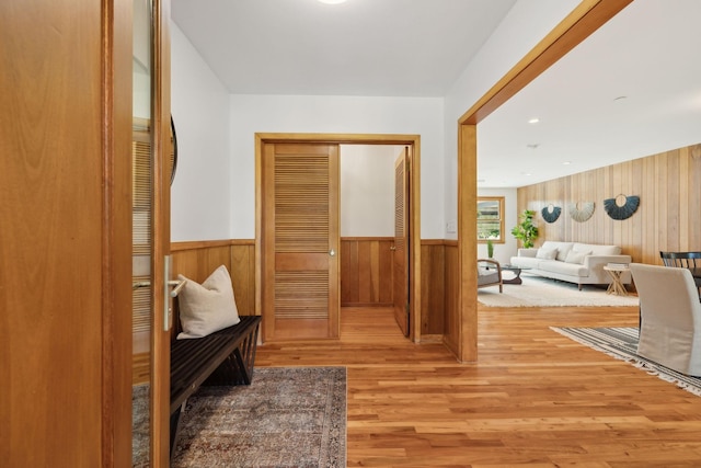 interior space with wood walls and light hardwood / wood-style flooring