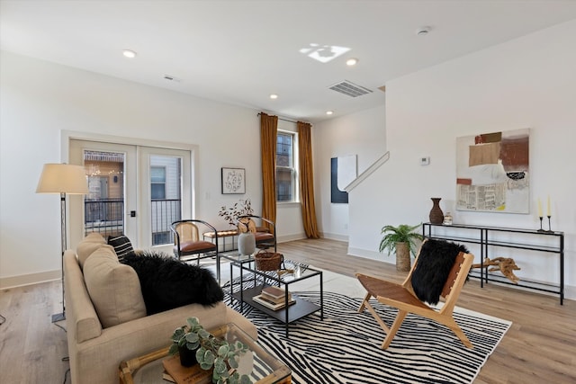 living room with french doors and light wood-type flooring