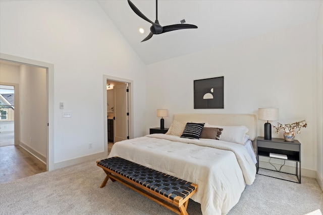 carpeted bedroom with high vaulted ceiling, ensuite bath, and ceiling fan