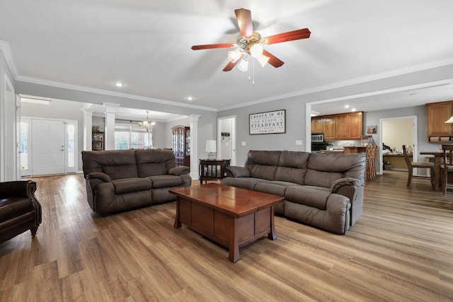 living room with ceiling fan, light hardwood / wood-style flooring, ornamental molding, and ornate columns