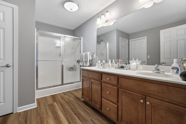 bathroom featuring vanity, hardwood / wood-style flooring, and a shower with door