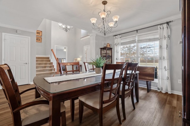 dining space featuring dark wood-type flooring, ornamental molding, and an inviting chandelier