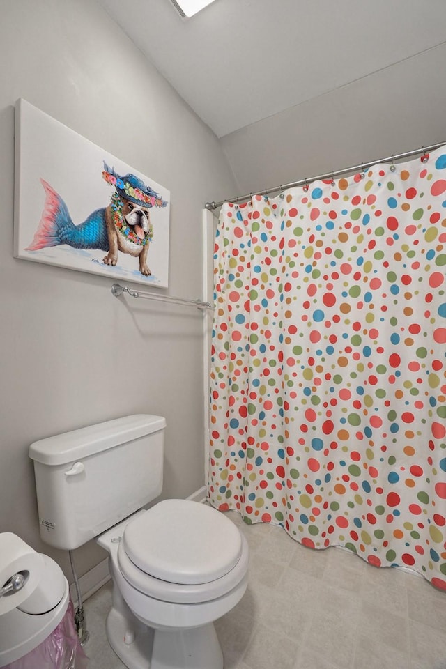 bathroom with toilet and a shower with shower curtain