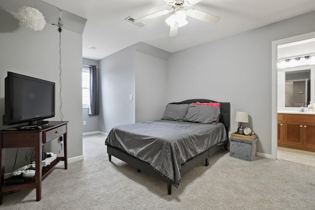 bedroom with ceiling fan, ensuite bath, light carpet, and sink