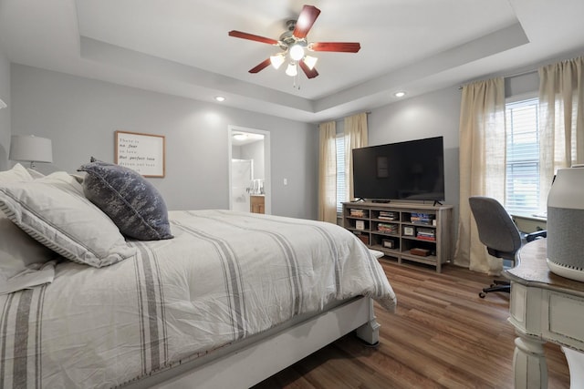 bedroom with ceiling fan, connected bathroom, and a raised ceiling