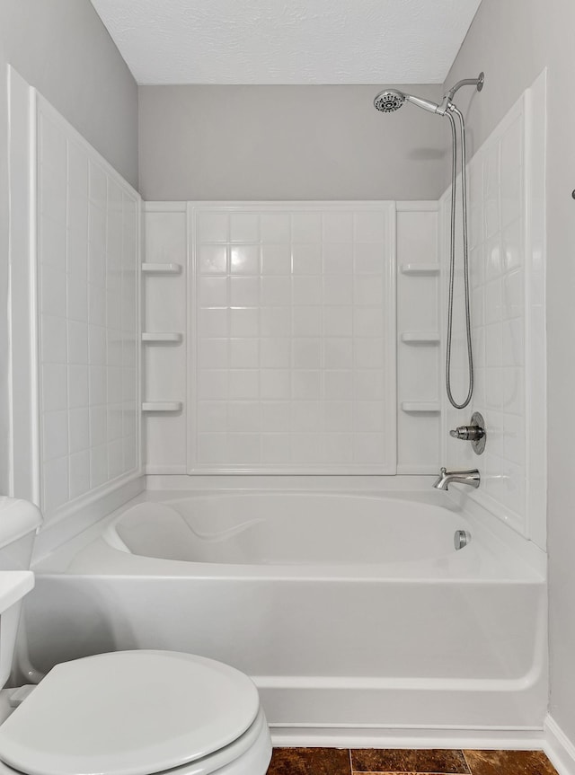 bathroom with toilet, bathing tub / shower combination, and a textured ceiling