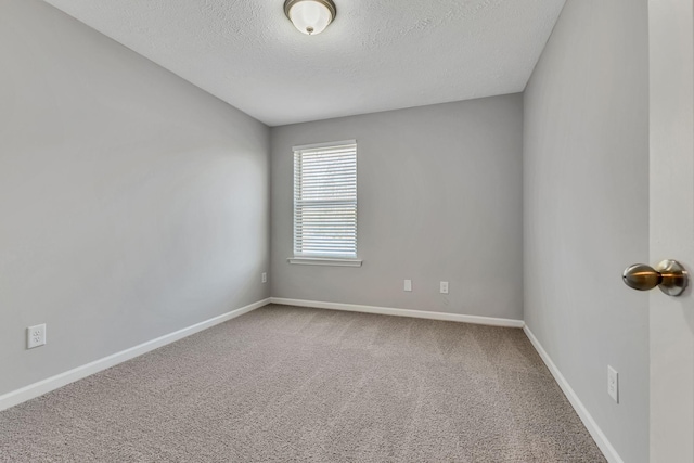 unfurnished room with a textured ceiling and carpet floors