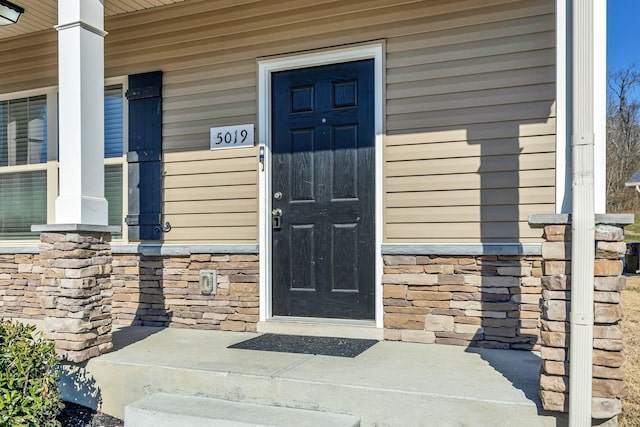 view of exterior entry featuring covered porch